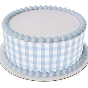 May include: A round cake with a light blue gingham pattern on the sides and a white top. The top and bottom edges are decorated with light blue frosting. The cake sits on a white cardboard base.