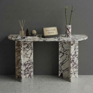 Puede incluir: Una bandeja de servir de madera hecha a mano con acabado natural. La bandeja tiene forma rectangular, bordes elevados y asas integradas. La veta de la madera es visible. Dimensiones: aproximadamente 40 cm de largo y 25 cm de ancho.