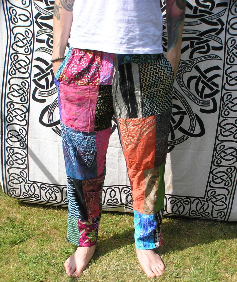 May include: Patchwork pants with a variety of colors and patterns, including pink, blue, green, and orange. The pants are made from different fabrics and are sewn together to create a unique and colorful design.