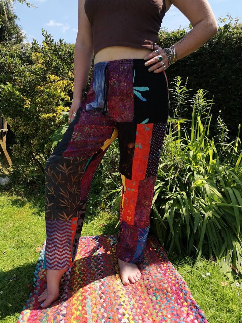 May include: Patchwork pants with a variety of colors and patterns, including black, red, orange, yellow, blue, and green. The pants have a drawstring waist and a relaxed fit.