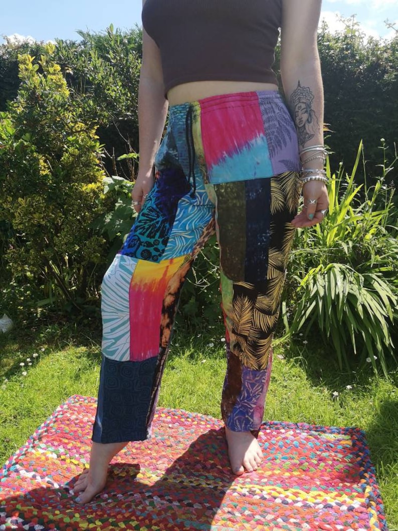 May include: Patchwork pants with a colorful, abstract design. The pants have a drawstring waist and a relaxed fit.