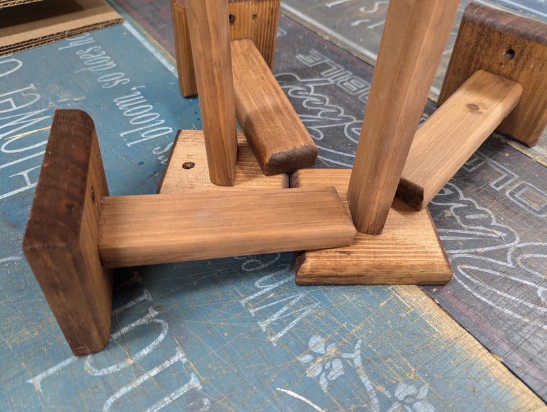 K&ouml;nnte beinhalten: Vier Holz-Regalb&ouml;cke mit einer dunkelbraunen Beize. Die B&ouml;cke sind aus massivem Holz gefertigt und haben ein schlichtes, rustikales Design.