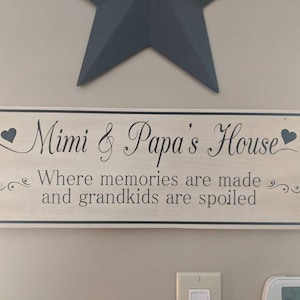 Könnte beinhalten: Ein Holzschild mit schwarzem Text, der "Mimi & Papa's House" mit Herzen auf beiden Seiten lautet. Der Text darunter lautet "Where memories are made and grandkids are spoiled."