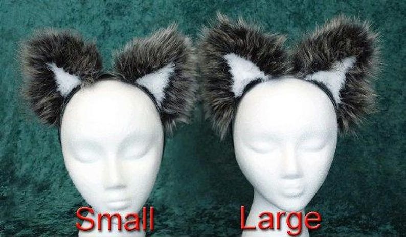 May include: Two sets of furry black and white ears on headbands. The headband on the left is labeled 'Small' and the headband on the right is labeled 'Large'.