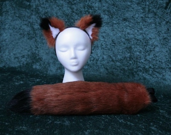 May include: A red and black faux fur tail and matching headband. The tail is long and fluffy, with a black tip. The headband is made of a black elastic band with a red and black faux fur ear piece on each side.