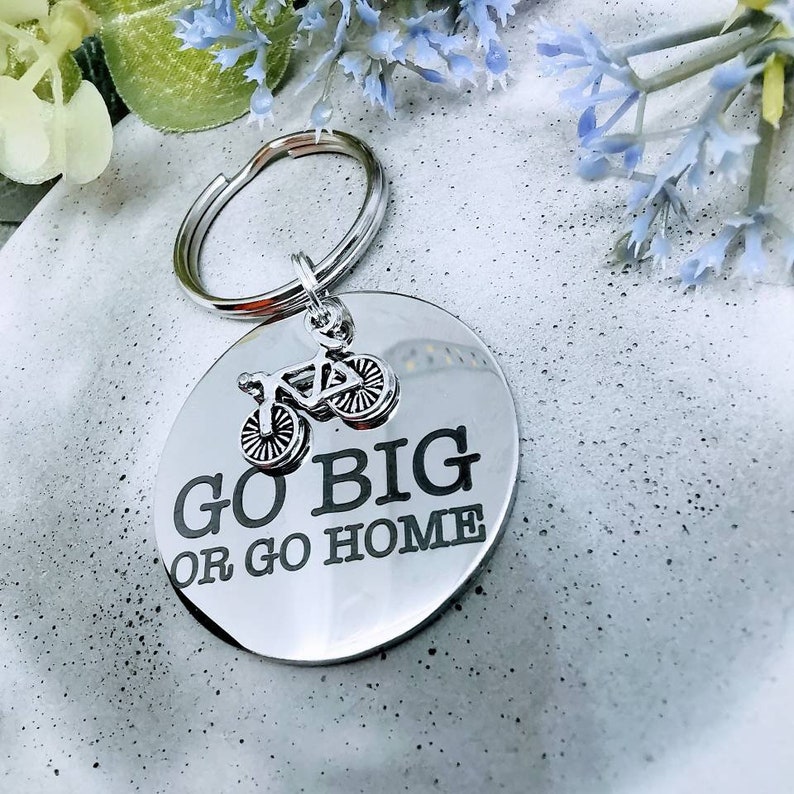 May include: Silver keychain with a round tag that says "Go Big or Go Home" with a small bicycle charm attached.