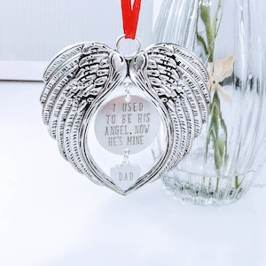 May include: Silver angel wing ornament with a heart-shaped charm that reads "DAD" and a round charm that reads "I USED TO BE HIS ANGEL. NOW HE'S MINE".