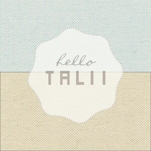 May include: A white circle with a scalloped edge on a blue and beige textured background. The circle has the text "hello TALI" in grey.