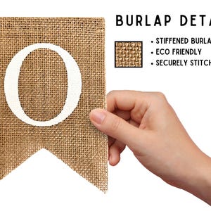 May include: A burlap banner with the letter "O" printed in white. The banner is made of stiffened burlap and has a securely stitched fold. The banner is eco-friendly.