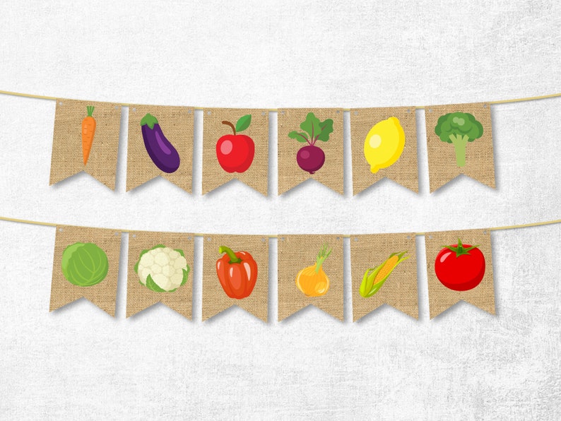 K&ouml;nnte beinhalten: Ein Banner aus Jute mit einer Reihe von Flaggen, die verschiedene Fr&uuml;chte und Gem&uuml;se zeigen, darunter eine Karotte, eine Aubergine, ein Apfel, eine Rote Bete, eine Zitrone, Brokkoli, Kohl, Blumenkohl, Paprika, eine Zwiebel, Mais und eine Tomate.