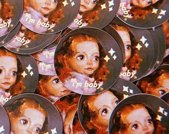 May include: A collection of round stickers featuring a cartoon girl with long brown hair and the text "I'm baby". The stickers have a dark background with glitter accents.