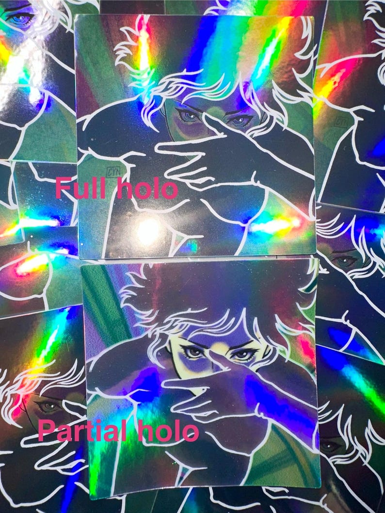 May include: Holographic stickers featuring a stylized illustration of a person with blue eyes and white hair, partially obscuring their face with a hand gesture. The stickers have a rainbow sheen and the text "Full holo" and "Partial holo".