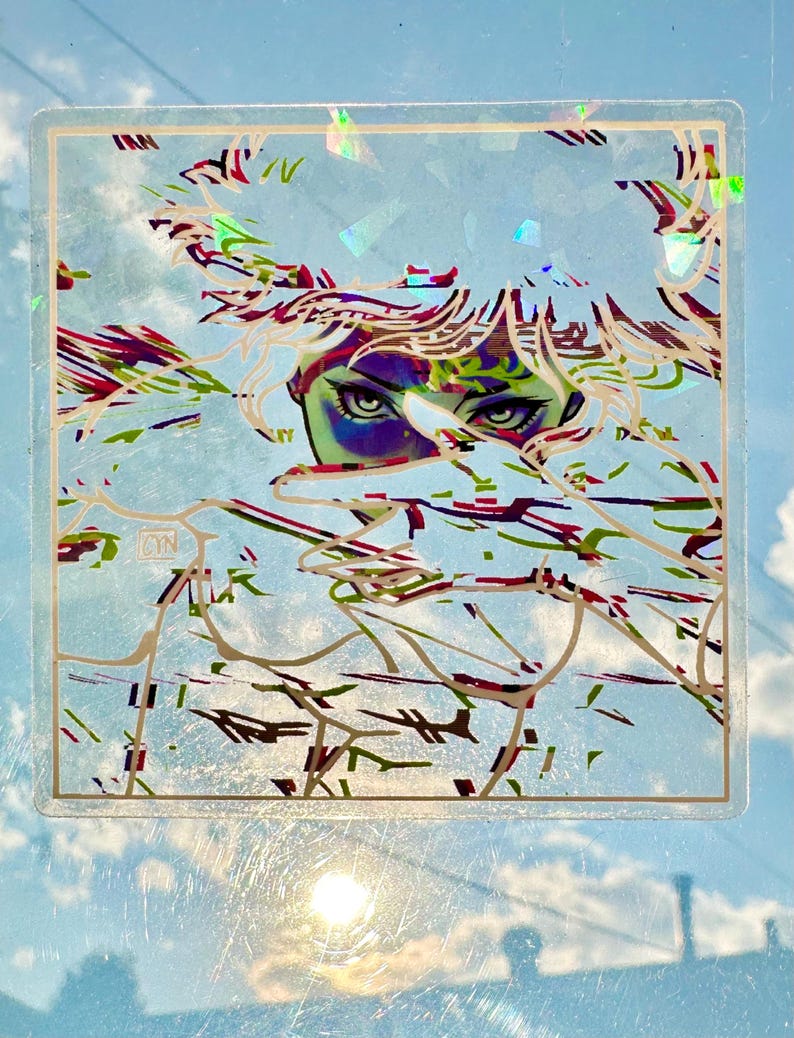 May include: A clear, square sticker featuring an artistic illustration of a person's eyes and part of their face, with a background of abstract lines in green, red, and white. The sticker has a gold border and the initials "CYN" in the corner.