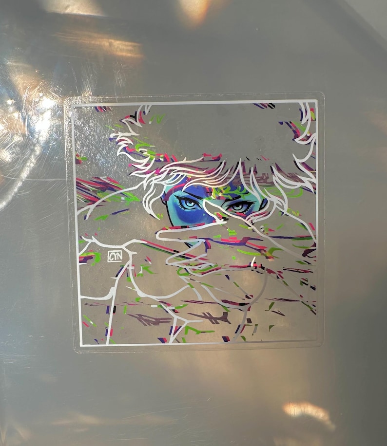 May include: A sticker featuring an illustration of a person with blue eyes and white hair. The artwork has colorful accents of pink, green, and purple. The artist's initials, CYN, are in the lower left corner.