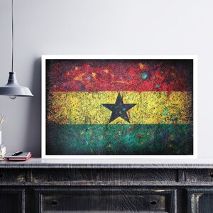 Puede incluir: Una impresi&oacute;n enmarcada de la bandera de Ghana. La bandera es una franja horizontal tricolor de rojo, amarillo y verde con una estrella negra de cinco puntas en el centro de la banda amarilla. La bandera est&aacute; pintada en un estilo texturizado con un efecto grunge.