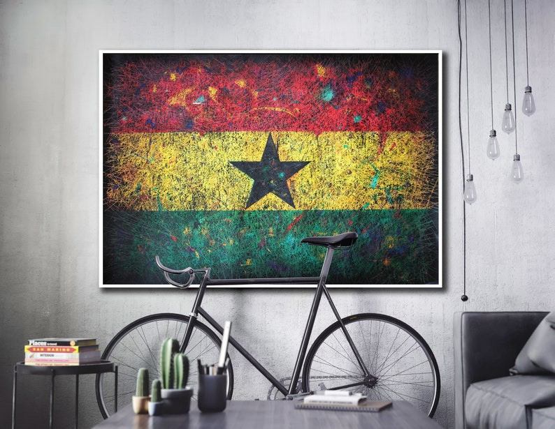 Puede incluir: Una bicicleta negra con un cuadro blanco y un sill&iacute;n negro est&aacute; delante de una pared con una pintura de la bandera de Ghana. La bandera es roja, amarilla y verde con una estrella negra en el centro. La pintura est&aacute; en un marco blanco.