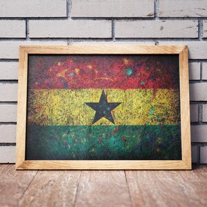 Puede incluir: Una impresi&oacute;n enmarcada de la bandera de Ghana. La bandera es roja, amarilla y verde con una estrella negra en el centro. El marco es de madera y tiene un aspecto desgastado.
