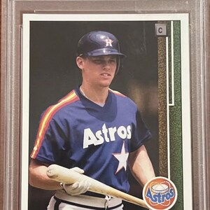 Puede incluir: Una tarjeta de béisbol Upper Deck de 1989 con Craig Biggio de los Houston Astros. La tarjeta está en perfecto estado y tiene una calificación de 9. La tarjeta presenta una foto de Biggio con su uniforme de los Astros sosteniendo un bate.