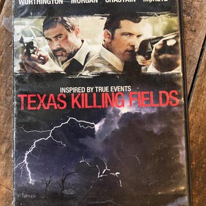 Puede incluir: Carcasa de DVD de la película "Texas Killing Fields" con Sam Worthington, Jeffrey Dean Morgan, Jessica Chastain y Chloë Grace Moretz. La portada muestra a dos hombres con armas, un cielo tormentoso y el lema "No One Is Safe."