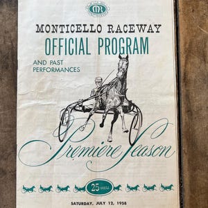May include: Vintage Monticello Raceway Official Program from 1958. The cover features a black and white illustration of a horse-drawn sulky and driver. The program is printed in green and black ink on aged paper. The text reads "Premiere Season".