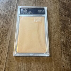 May include: A clear plastic case with a white card inside. The card has a black label with the text "Professional Sports Authenticator, A Division of Collectors Universe,  Sarasota, FL."