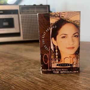 May include: A cassette tape with a photo of Gloria Estefan on the cover. The title of the album is "Turn the Beat Around" and the text "Music from the Motion Picture THE SPECIALIST" is printed below the photo.