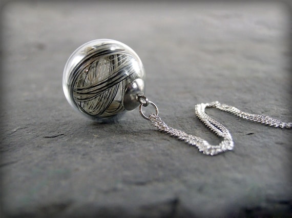 Glass sphere pendant containing horse or pet hair