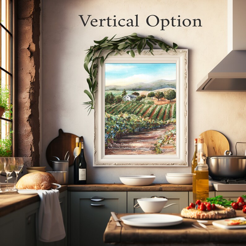 May include: A framed painting of a vineyard landscape with a white farmhouse in the distance. The painting is hanging on a wall in a kitchen with a wooden countertop and a window with a view of greenery.