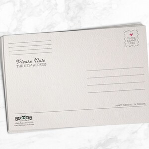 May include: A white postcard with a place to put a stamp and a line that says "Please Note The New Address".