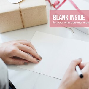 May include: A blank white card with a pen on a white surface. The text "BLANK INSIDE for your own personal message." is on a pink background.