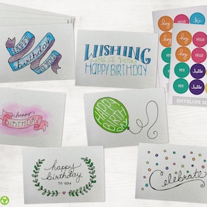 May include: Set of six illustrated birthday cards with different designs. The cards feature colorful illustrations of balloons, ribbons, and wreaths with the text "Happy Birthday" in various styles. The cards are printed on textured paper.