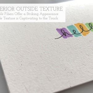 Pu&ograve; includere: Primo piano di un biglietto bianco con una superficie testurizzata. Il biglietto ha il testo "SUPERIOR OUTSIDE TEXTURE" e "Visible Fibers Offer a Striking Appearance" e "Gentle Texture is Captivating to the Touch" stampato su di esso. La parola "hello" &egrave; scritta con un pennarello colorato nella parte superiore del biglietto.