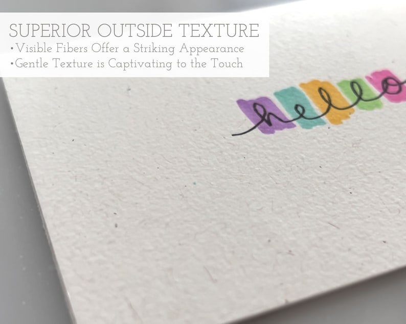 May include: A close-up of a white card with a textured surface. The card has the text "SUPERIOR OUTSIDE TEXTURE" and "Visible Fibers Offer a Striking Appearance" and "Gentle Texture is Captivating to the Touch" printed on it. The word "hello" is written in colorful marker across the top of the card.