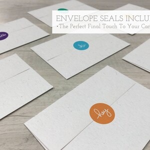 Pu&ograve; includere: Cinque buste bianche con adesivi rotondi di diversi colori. Gli adesivi hanno le parole "hello", "hi", "hey", "hello" e "hi" scritte su di essi. Il testo "ENVELOPE SEALS INCLUDED" e "The Perfect Final Touch To Your Card" &egrave; nella parte superiore dell'immagine.