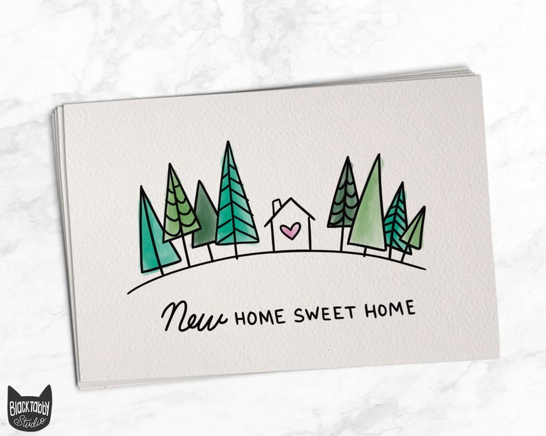 May include: A greeting card with a hand-drawn illustration of a house with a heart in the window, surrounded by green trees. The text "New Home Sweet Home" is written below the illustration.