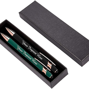 May include: Two pens in a black gift box. One pen is black with rose gold accents, the other is dark green with rose gold accents. Both pens have the text "Your Imprint Here" in a script font.