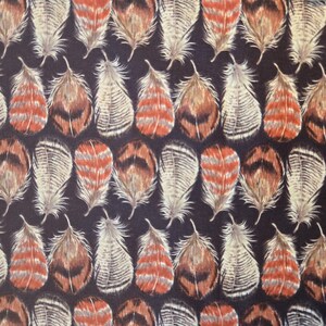 May include: A repeating pattern of stylized feathers in shades of brown, orange, and white against a dark navy blue background. The feathers are arranged in a grid-like formation, creating a textured and visually appealing design.