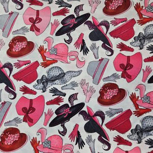 May include: A white fabric with a repeating pattern of pink, red, and black hats with gloves. The hats are decorated with bows, polka dots, and flowers.