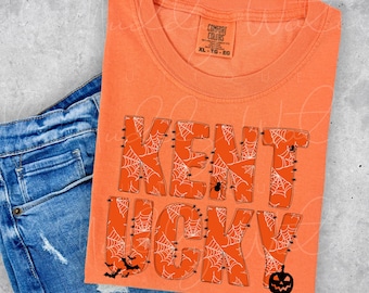 May include: Orange t-shirt with the words "KENTUCKY" in black outlined letters with a spiderweb pattern. The letters are stitched with black thread. There are bats and a pumpkin on the shirt.