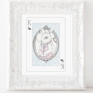 May include: A white rabbit wearing a pink and white striped shirt and a pocket watch, holding a cigarette. The rabbit is depicted on a playing card with the letter 'K' in the corner. The card has a blue and white background with a floral pattern.