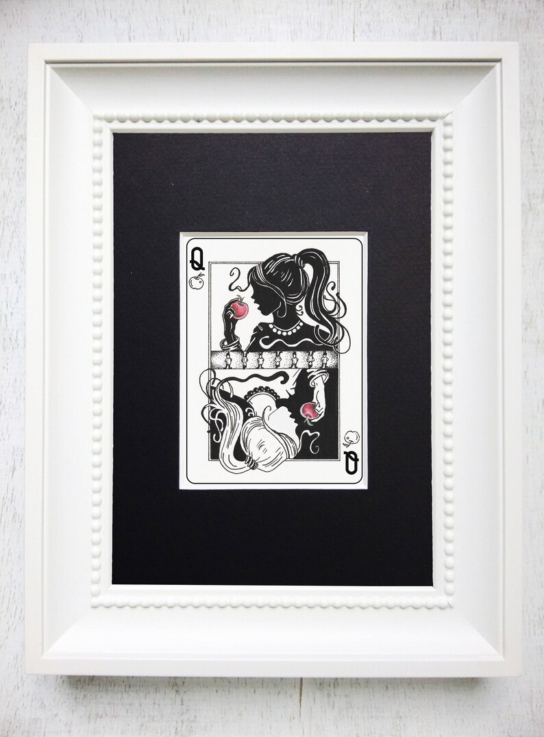 May include: A framed black and white illustration of a queen of hearts playing card. The queen is depicted as a silhouette with a red apple in her hand. The card is framed in a white frame with a beaded border.