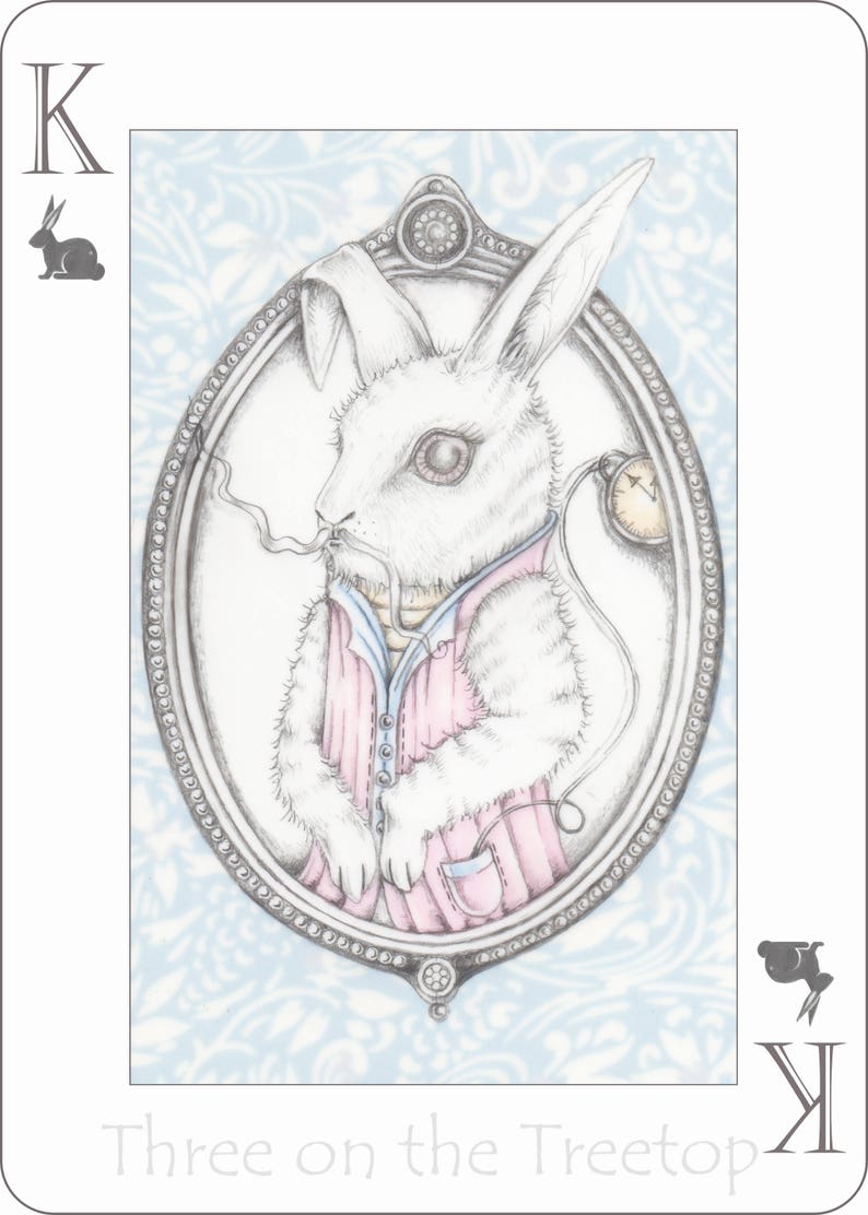 May include: A white rabbit wearing a pink shirt and a pocket watch, in a silver oval frame with a blue and white patterned background. The text "Three on the Treetop" is below the frame.