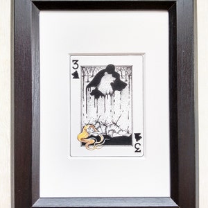 Pu&ograve; includere: Un'illustrazione in bianco e nero di una carta da gioco, il tre di fiori. La carta rappresenta una donna sdraiata con una creatura simile a un lupo sopra di lei. Il lupo sta gocciolando un liquido nero.