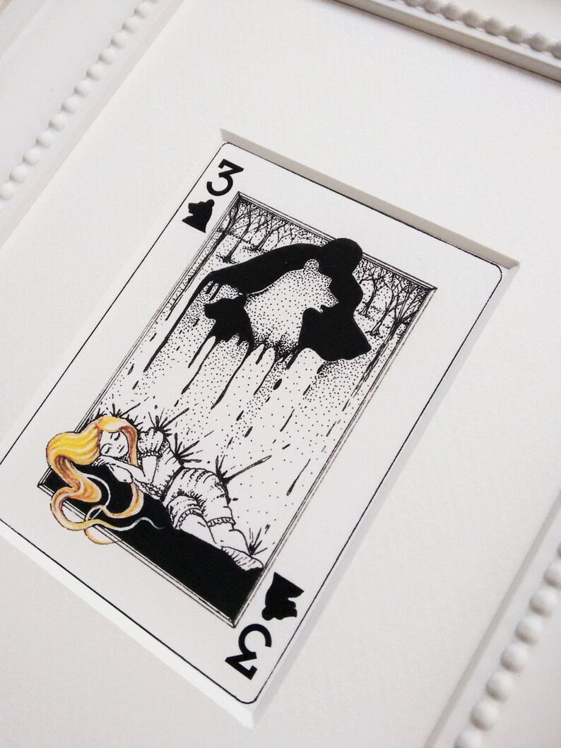 Pu&ograve; includere: Un'illustrazione in bianco e nero di una donna addormentata con i capelli biondi, sdraiata su un letto di spine. L'illustrazione &egrave; su una carta da gioco con il numero 3 di fiori nel angolo.