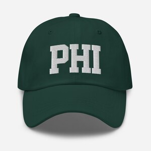 May include: A dark green baseball cap with a white embroidered "PHI" on the front.