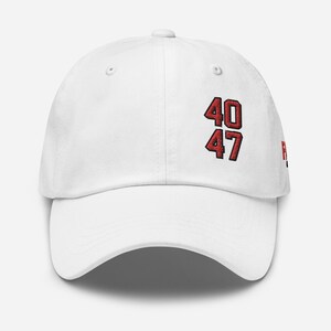 May include: White baseball cap with the numbers "40" and "47" embroidered in red on the front. The hat has a curved brim and a classic six-panel design. The hat is made of a soft, durable material.