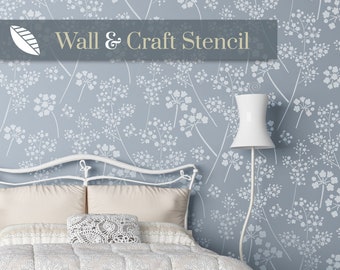 Puede incluir: Una cama con un cabecero de metal blanco, un edredón blanco y dos almohadas. La pared detrás de la cama está pintada de azul claro y presenta un diseño de flores delicadas en blanco con una plantilla.