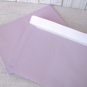 May include: Two lavender-colored envelopes, one open to reveal a white interior. The envelopes are made of a smooth paper and are set against a neutral background. The open envelope has a white flap.