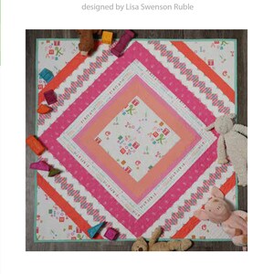 May include: A pink and white quilt with a diamond pattern in the center. The quilt is surrounded by a border of pink, orange, and white fabric. The quilt is 45 inches square and is designed by Lisa Swenson Ruble. The quilt is called "Rhombi".