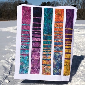 Peut inclure: Un panneau de tissu blanc avec six bandes verticales de tissu coloré. Les bandes sont faites d'un tissu marbré tourbillonnant dans des tons de bleu, violet, orange et jaune. Chaque bande a une série de lignes horizontales d'une couleur contrastante.